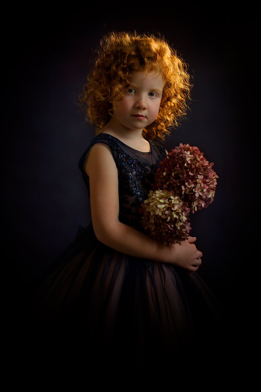 Canon-EOS-R-Fine-art-portrait-of-a-little-young-curly-red-head-girl-with-flowers-in-her-hand-standing-in-a-blue-wedding-dress-like-Rembrandt-by-Willie-Kers