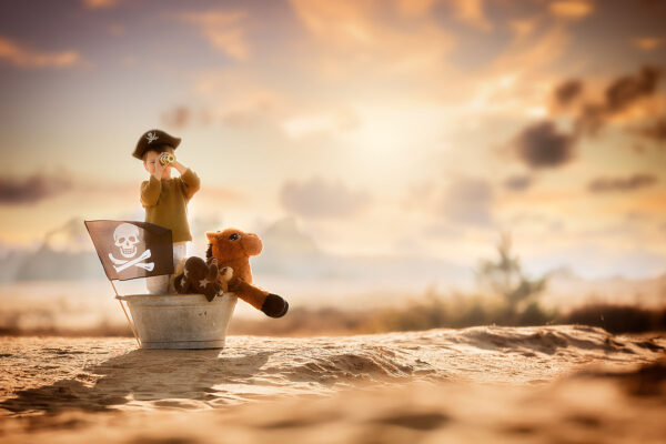 Fine-art-child-portrait-of-a-little-pirate-boy-sailing-in-the-desert-by-dutch-natural-light-photographer-Willie-Kers