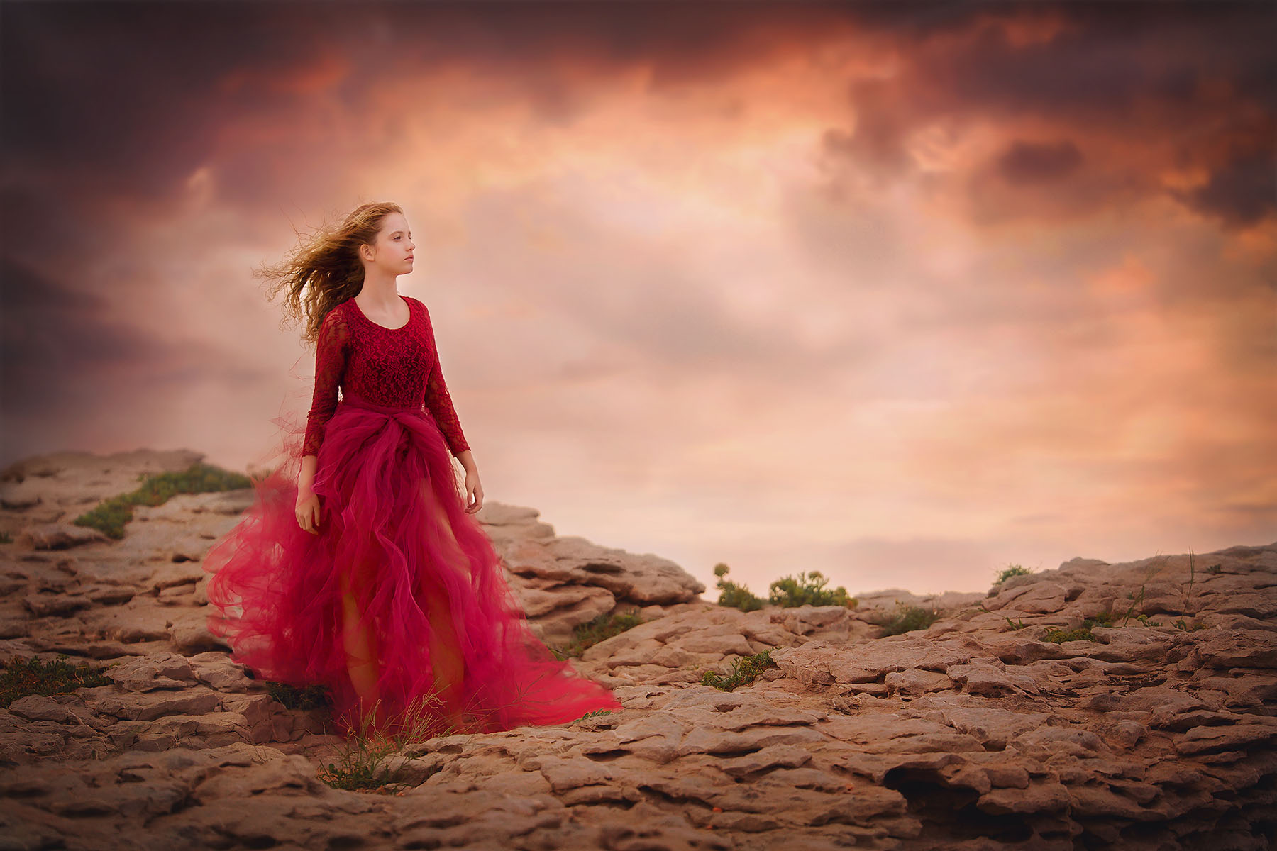 image-of-a-girl-in-a-red-dress-standing-on-the-rocks-of-a-mountain-at-Mallorca-beach-by-Willie-Kers